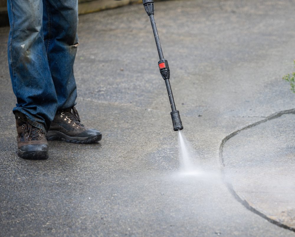 a person cleaning the floor with pressure wash
